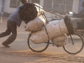 Un commerçant transportant des sacs de braise sur un vélo à Mbuji-Mayi le 17 juin 2011